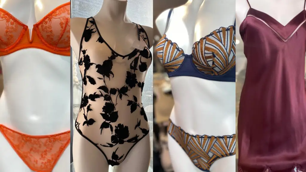 A collection of elegant lingerie and sleepwear, featuring a vibrant orange lace set, a sheer bodysuit with black velvet floral embroidery, a navy and gold geometric embroidered set, and a burgundy satin chemise with lace trim, all displayed on mannequins in a boutique setting.